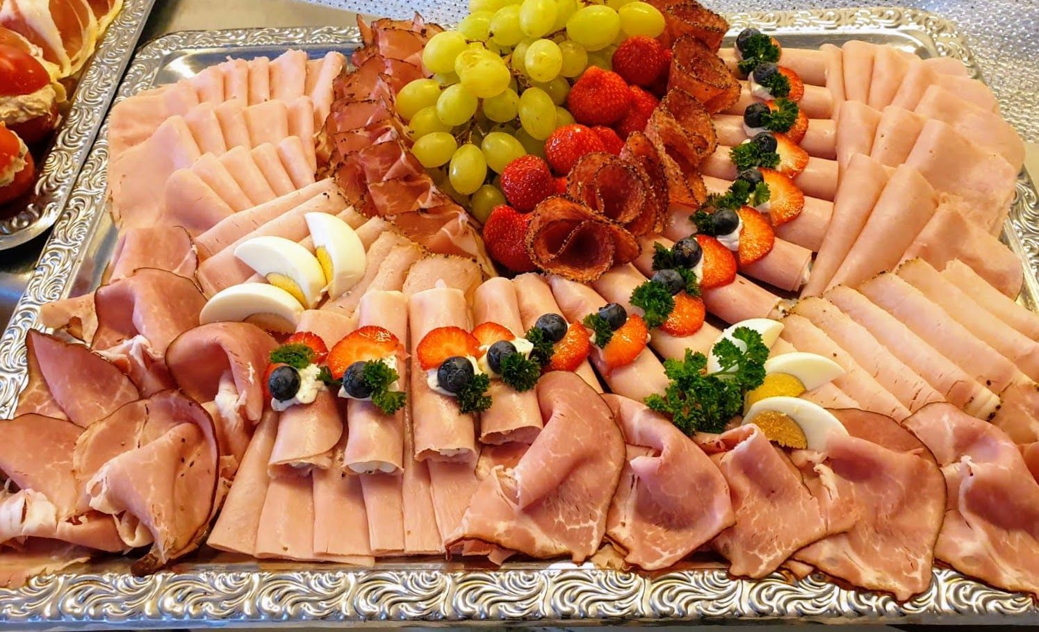 Aufschnittplatte mit Schinkenröllchen und Obst Garnierung 